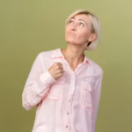 impressed-young-blonde-slavic-woman-holding-fist-isolated-olive-green_141793-32983